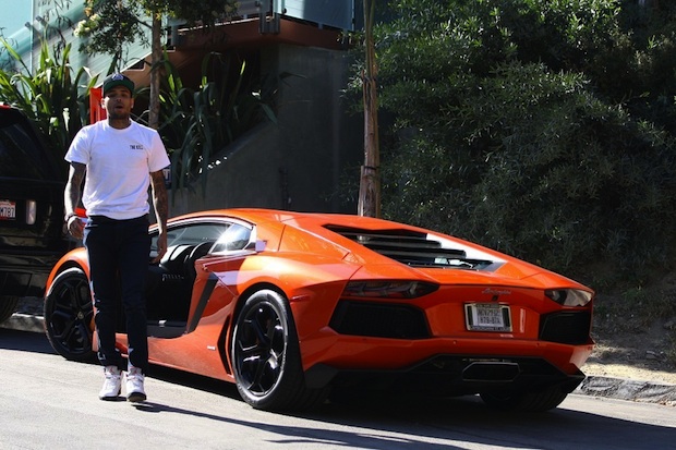 Chris-Brown-gets-out-orange-Lamborghini-Aventador-wearing-Black-Pyramid-hat-The-Kill-tee-shirt-Air-Jordan-Retro-5-Sneakers-Upscalehype-4